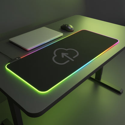 Gaming desk setup with a large mouse pad, laptop, and mouse on a dark surface.