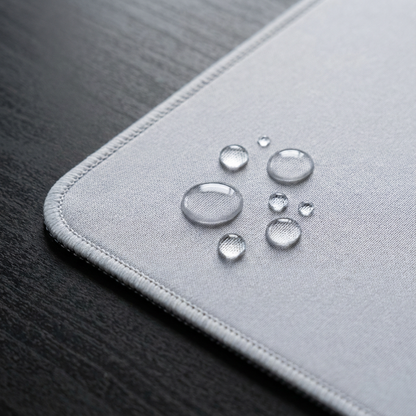 Close‑up of custom mousepad surface with water droplets on the printed cloth top, showing the water‑resistant coating.